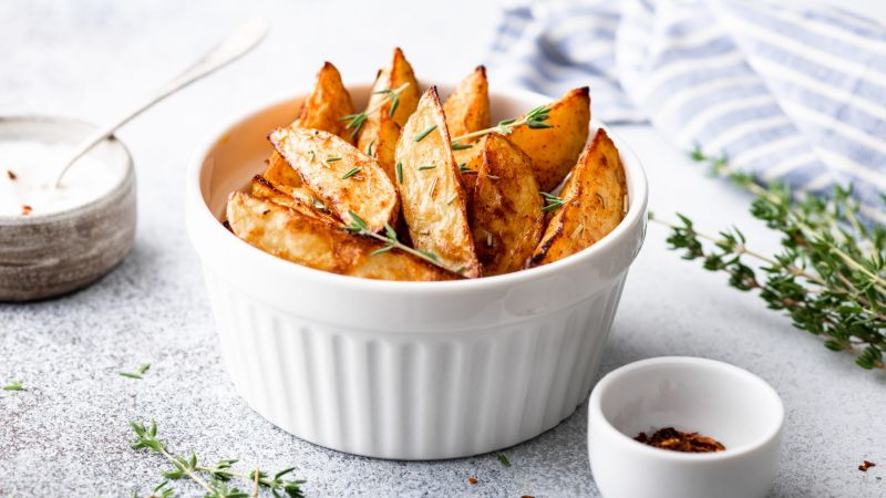 baked potato wedges with sauce on a light background