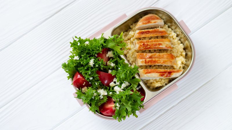 Take away lunch in reusable lunchbox with healthy food top view